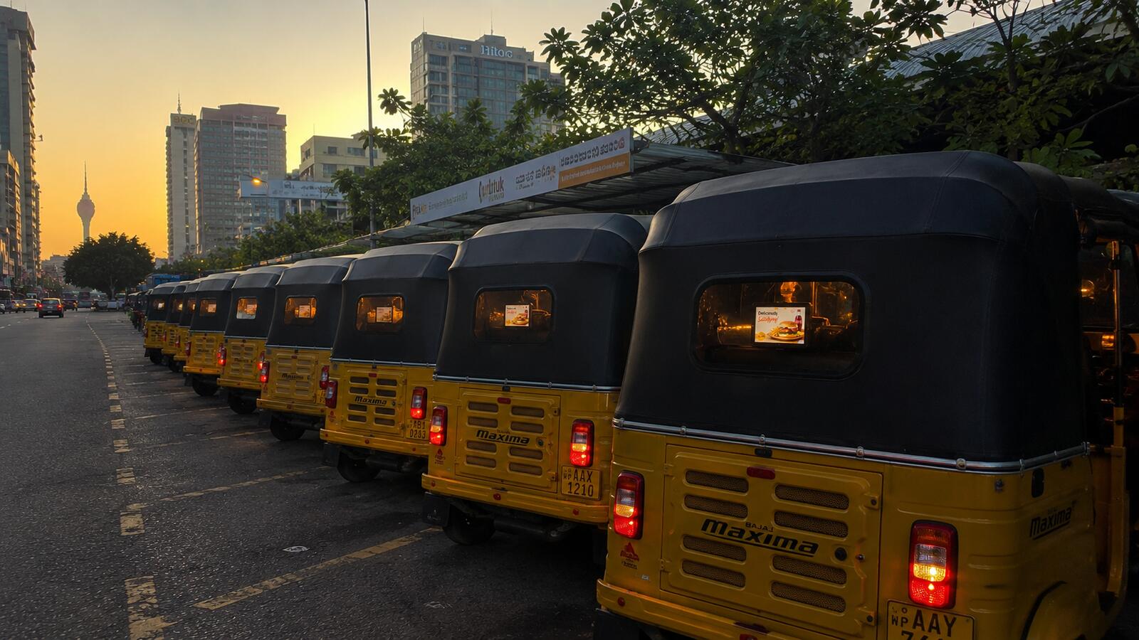 A line of mydiio tuk-tuks parked at sunset in Colombo